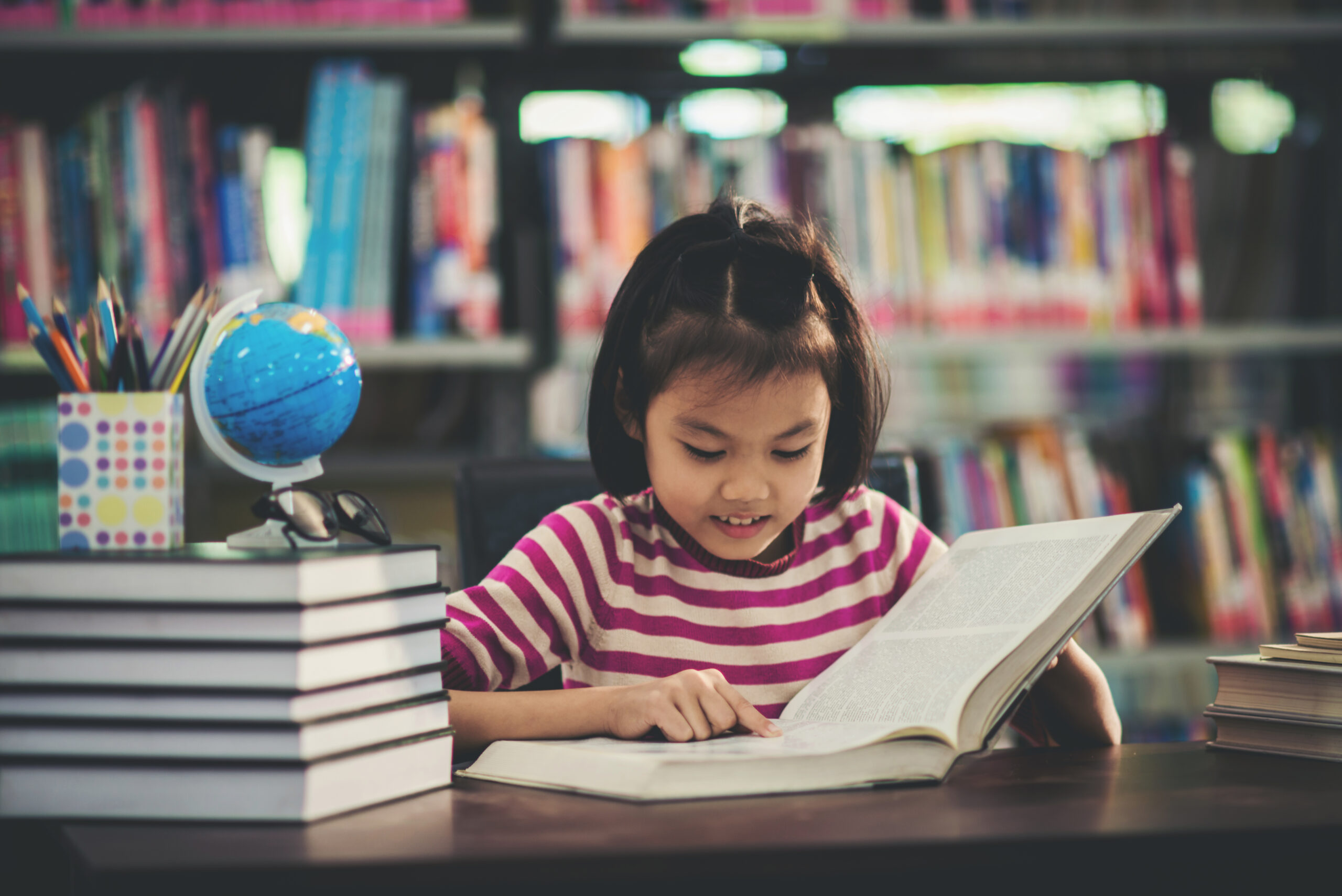 Portrait of a student child girl studying at library,Learning Concept